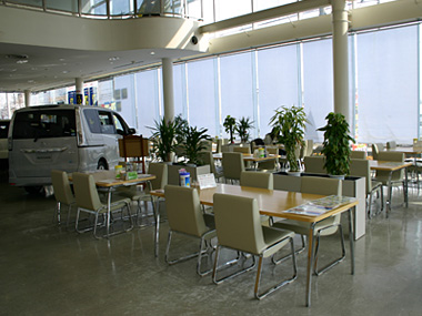 壁一面が大きな窓の明るい店内は、常時新型車が多数レイアウトされ、十分なスペースでお客様のご来店をお待ちしております。