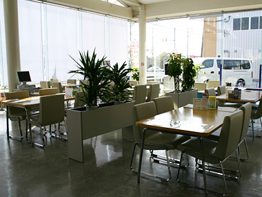 ご希望の展示車を前に、カーライフアドバイザーがお客様のご質問にお応えいたします。機能的な店内レイアウトも自慢の一つです。