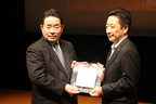 「マツダ デミオ」10ベストカー選出の表彰にて盾を受け取るマツダ株式会社 商品本部主査 土井歩氏