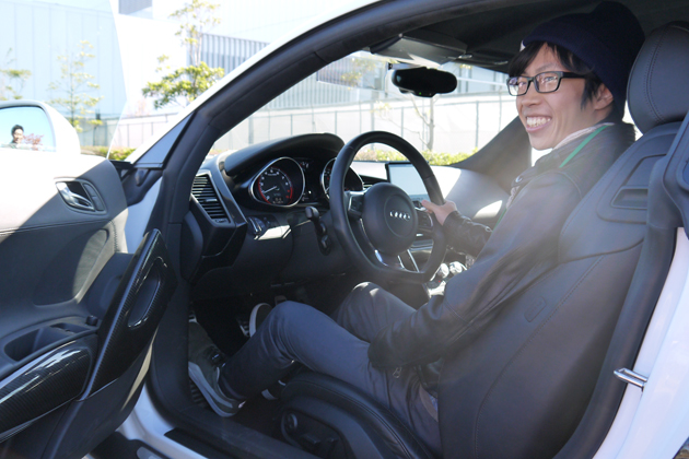 学生カーソムリエの湯川さん。特別に座らせていただいたアウディR8の運転席にて