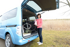 e-NV200のラゲッジから積んでいたロードバイクを降ろす飯田裕子さん