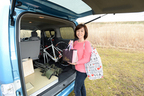 e-NV200のラゲッジから積んでいたロードバイクを降ろす飯田裕子さん