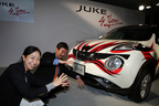 「JUKE by YOU」デカールデザインコンテスト グランプリ作品の前にて、日産自動車（株）商品広報部の若井さん（左）とジュークの歌舞伎顔をマネする志水さん（右）