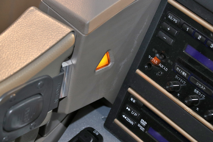 「アクティブ・サイドガード・アシスト」でレーダーが左側面の歩行者や自転車、クルマ、障害物などを検知した際にはインパネ左側の△表示ランプが黄色く点灯。ウィンカーを出した際には赤く光る／三菱ふそう 大型観光バス「エアロクイーン」2019年モデル(スーパーハイデッカー／観光・貸切／撮影用特別仕様車)／三菱ふそう 大型観光バス発表会[2019年2月21日／会場：パシフィコ横浜(神奈川県横浜市)]