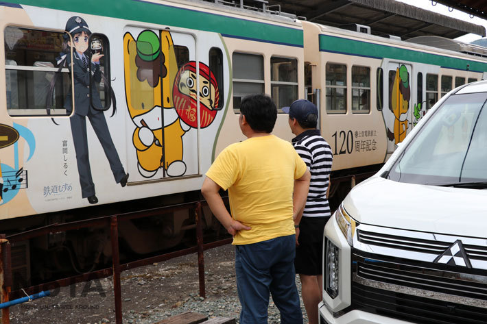 ご当地キャラ「ぐんまちゃん」と鉄道むすめ「富岡しるく」ちゃんが競演！ ぐんまちゃんの手にあるのは高崎だるま！[上信電鉄 南蛇井(なんじゃい)駅(群馬県富岡市)]