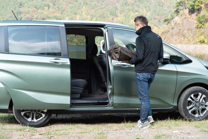 両手に荷物を抱えていてもフロントドアの下に足を差し込んで引けば、スライドドアを自動で開くことができる