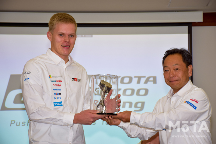 記念品を手にしたオット・タナク選手と青木エンジニア