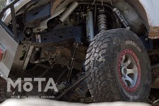 凹凸の多いオフロードをがっちりと掴むための大径タイヤの直径は怒涛の37インチ！（約94cm）まさしくNVカーゴXを象徴するポイントだ。  フロントの足回りはオフロードスペシャルとしてカスタムされ、リアは耐久性の高さを考慮してNV2500HDのリーフスプリング式を継承。凹凸路面で車体が斜めになろうが、豊かなストロークとしなやかな足回りで悪路を走り抜ける。