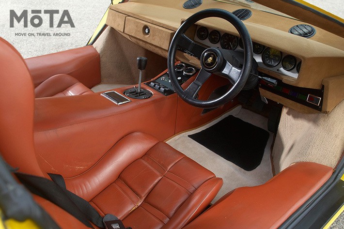 インテリアは運転に必要な装置以外が見当たらないシンプルな造形で、直線基調のダッシュボードにはメーター類が一列に並ぶ。そして、運転席と助手席を隔てるのは極太のセンターコンソール。またサイドシルも極太で、いかにもボディ剛性が高そうである。