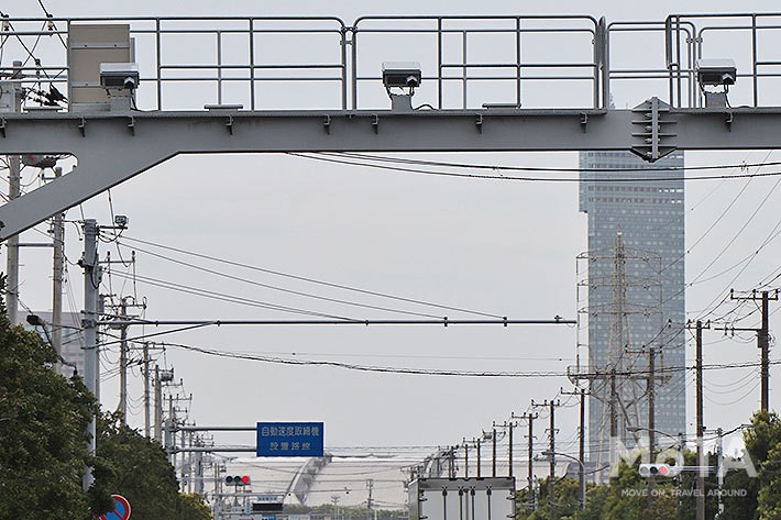 「自動速度取締機 設置路線」（オービス設置）事前告知看板が奥に見えるが、手前の機器はNシステム（自動車ナンバー自動読取システム）！ このような設置例はよく見られる。パニックブレーキを踏まないよう常に安全運転を心がけよう