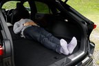 トヨタ 新型ハリアー ラゲッジ（荷室）での車中泊（イメージ）／荷室長は1805ｍｍ（トヨタ社内測定値）だが、実際には後席シート背もたれよりも頭が上に出てしまい浮いている状態。このままでは寝ることが出来ない。[モデルの身長180cm]
