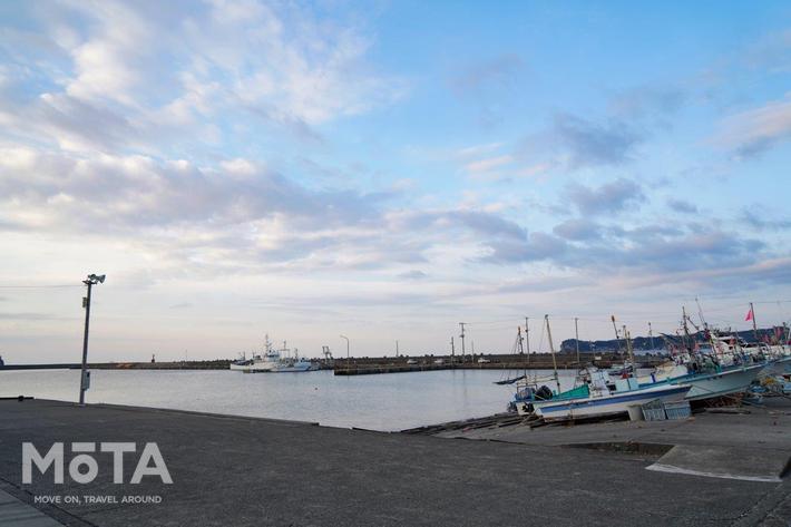 勝浦漁港には多数の漁船が出入りしている。写真左手には水揚げされる大きな建屋が設けられており、朝早い時間から、漁師をはじめとした多数の関係者が出入りしている。