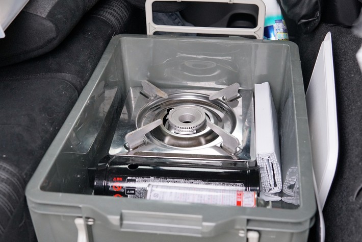 畳んだ2列目の足元とヘッドレストの間にぴったり収まる樹脂製ボックス。炊事道具が収納されている