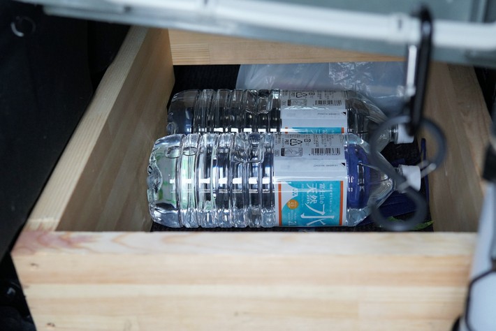 深さのある最下段（床面の凹凸に合わせてうまくハマるよう自作）には、水などを収納