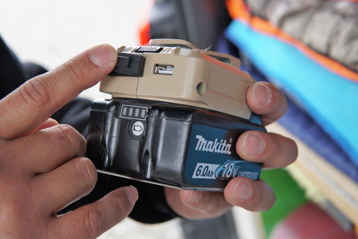 マキタのUSBアダプタ（上のベージュ部分）とバッテリー（下の黒いもの）を組み合わせ、モバイルバッテリーとして活用