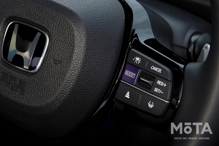［16/27］ホンダ 新型スーパーワン 内装 ステアリングスイッチ：右側スポークに配置された、押した瞬間にシステム出力を最大70kW（約95馬力）まで解放し、専用の加速演出を起動する紫色の「BOOST」ボタン